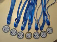 An arrangement of medals with blue ribbons on a beige background